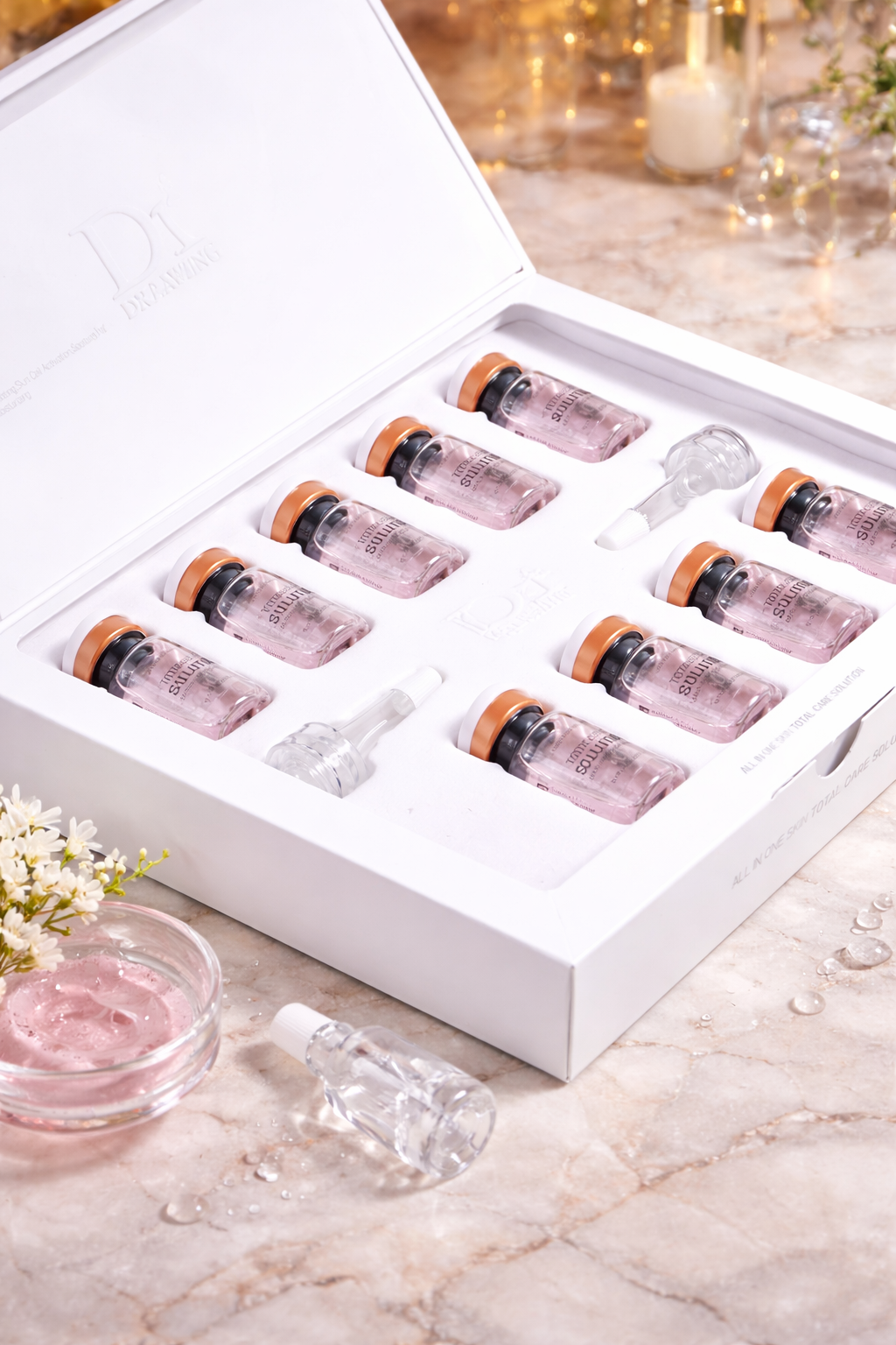 Set of Dr. Drawing Total Care Snail Mucin Ampoules with pink liquid in a white box on a marble surface.