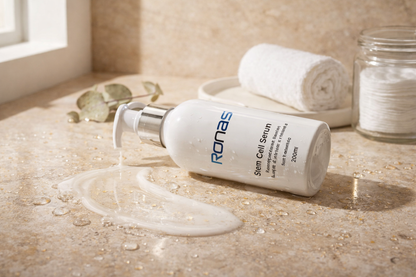 Ronas Stem Cell Serum bottle on a textured surface with a towel and jar in the background.